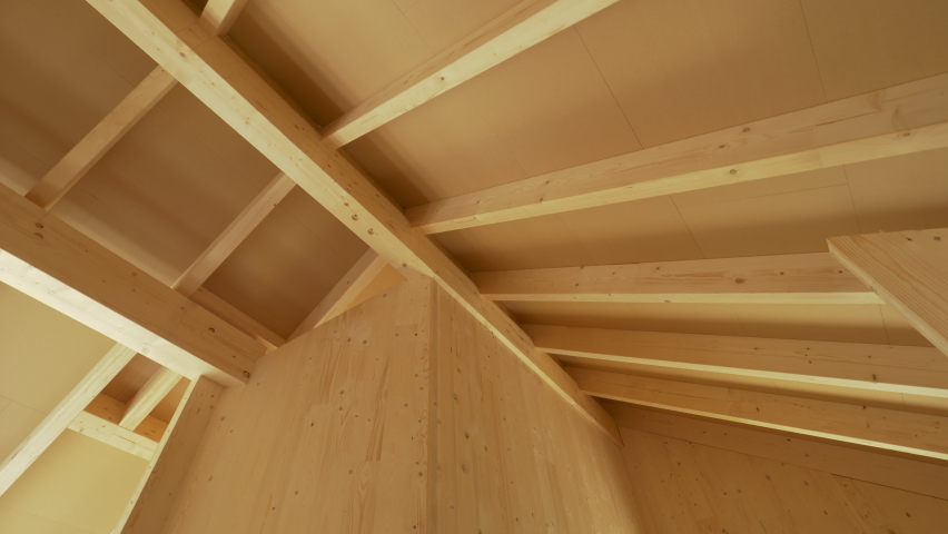 Beautiful view of the massive ceiling beams of a modern cross laminated timber house. Gorgeous hardwood structure of the ceiling of a contemporary glue laminated housing project under construction. Royalty-Free Stock Footage #1070463070