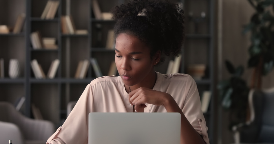 Focused young african ethnic female freelancer businesswoman working on computer at home office, thinking on difficult task or considering problem solution. Smart 25s biracial girl studying distantly. Royalty-Free Stock Footage #1070465992