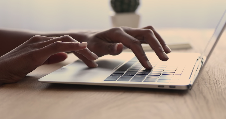 mixed race young woman typing on computer keyboard at table with