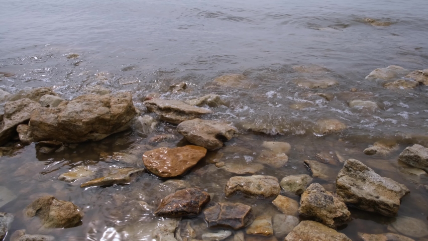 Stones on the seashore. The tide covers the stones and pebbles on the shore. The coast of the Sea of Azov