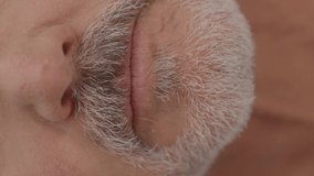 Bearded old man clenches his lips,  mouth plan. Concept of lips.Video for the vertical story.