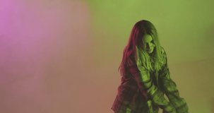 Stylish young teen girl cool dancing in neon colourful studio light. 4k video of modern dance