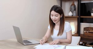 Young Asian woman uses a computer to work through the internet at home, Freelance.