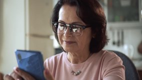 Old woman use cell phone, browse internet at home. Smiling mature 50s 60s female surfing messenger - Powered by Shutterstock - Get 15% off with code: PIKWIZARD15