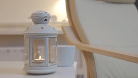 Candle warmer lamp near armchair in living room, modern apartment interior in the evening. High quality 4k footage