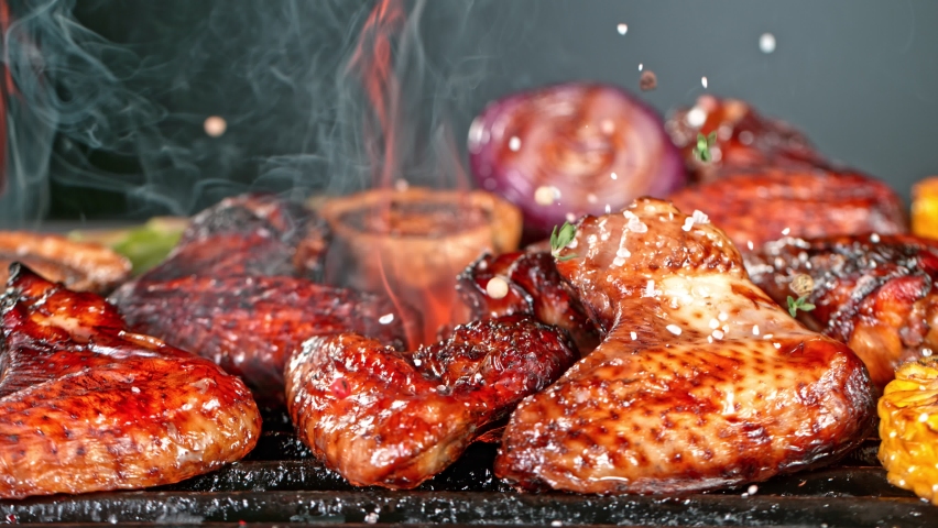 Super Slow Motion Shot of Seasoning Falling on Fresh Grilled Chicken Wings at 1000 fps. Royalty-Free Stock Footage #1070499385