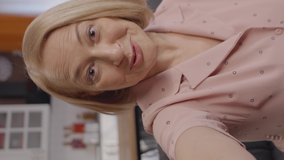 The old woman talks  by video to her family on the phone and sends a kiss. Video conversation concept.Front camera view.Video for the vertical story. - Powered by Shutterstock - Get 15% off with code: PIKWIZARD15