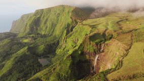 Poco Ribeira do Ferreiro, Alagoinha, Flores Island, Azores, Portugal. Aerial view of fajas from a viewpoint. Endemic vegetation covers coastal cliffs with seascape behind. High quality 4k footage