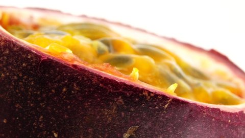 4K cross-section of a puple passion fruit Macro shot of sliced fresh exotic passion fruit fruit rotating  isolated on white background