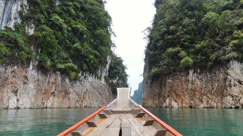 Amazing Travel Tour on Blue Lake on Wooden Longtail Boat Near Limestone Cliffs and Tropical Forest. Vacation and Trip Concept. Journey on Cheow Lan Lake Lagoon in Khao Sok National Park, Thailand