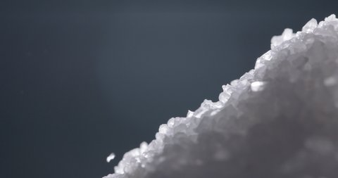 White salt granules falling into a pile. Bath cosmetic salt particles chaotically dropping - macro close up shot 4k footage