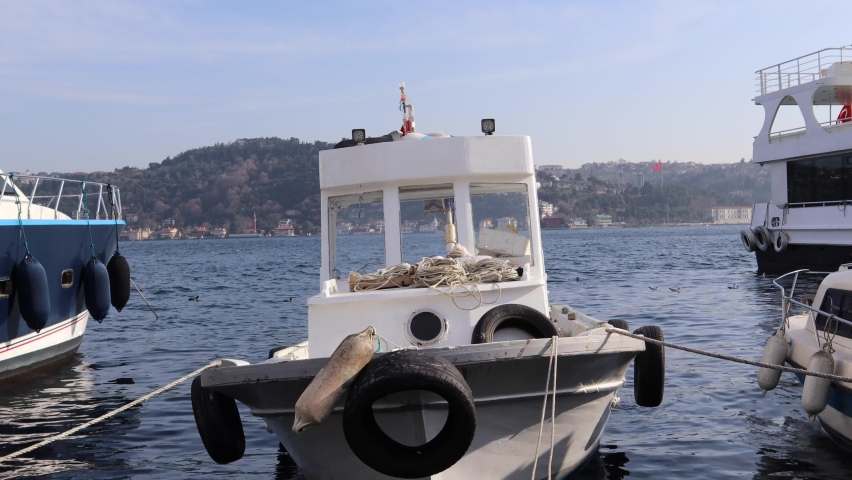 Ferry Boat And Fishing Boat Moored At Seaport By Bosphorus In Istanbul, Turkey. - wide shot