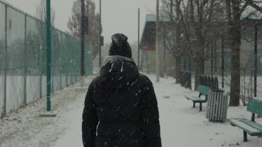 Woman in Black Coat Walks on Empty Snow Park Trail