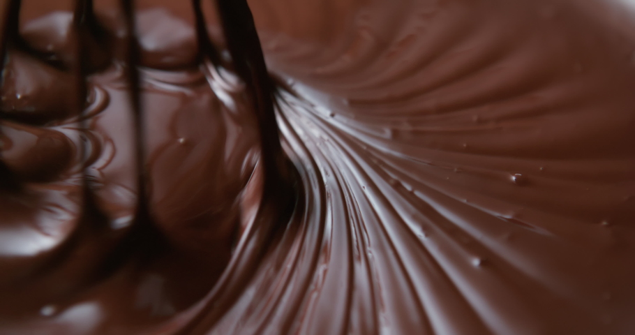 Close-up chocolatier mixing melted liquid chocolate with steel whisk. Hot chocolate mix and swirl in bowl. Cooking handmade chocolate dessert and candies. Confectionery concept Royalty-Free Stock Footage #1070536900