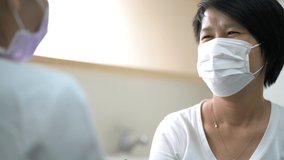 Asian woman patient wearing face mask talk with her doctor for checking up her health in hospital