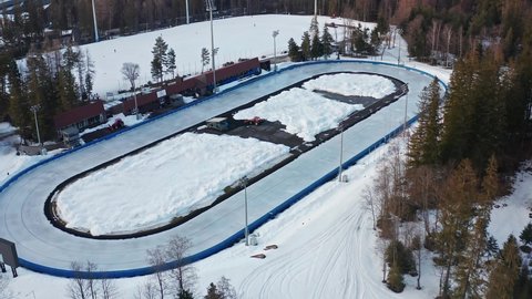 Artificially Frozen Skating Track On Snowy Landscape In Zakopane, Poland During Winter. COS Zakopane Empty Due To Coronavirus Pandemic. aerial drone descend