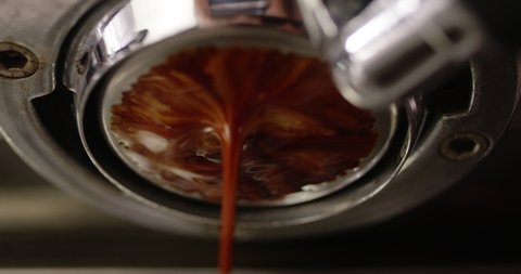 Coffee stream from espresso machine with no lever, low angle extreme closeup