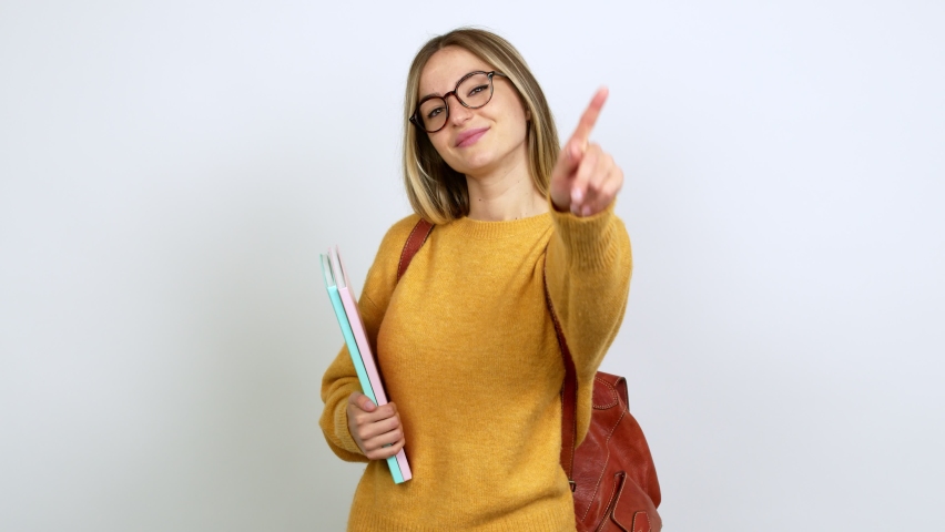 Young woman with backpack happy and counting with fingers over isolated background Royalty-Free Stock Footage #1070548681