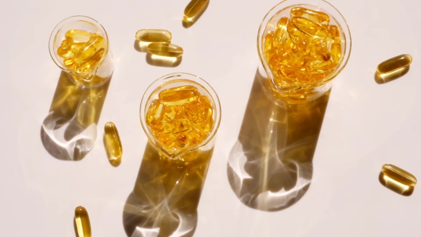 Fish  oil. Gelatin capsules of fish oil in glass flasks on a light background.omega fatty acids.Natural supplements and vitamins.Healthy eating and food supplements Royalty-Free Stock Footage #1070551120