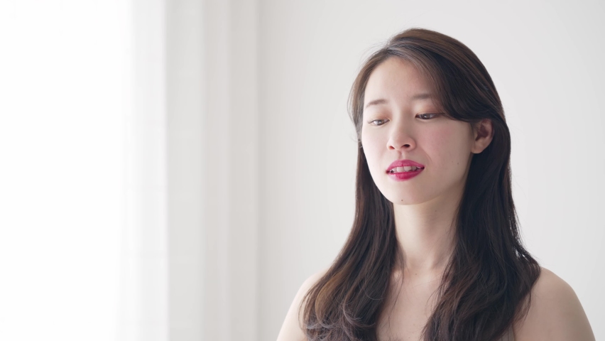 Young asian woman tying her hair. Hair care. Beauty concept. Slow motion.