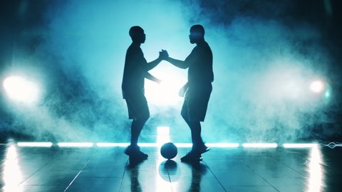 Two basketball players are shaking hands before the game