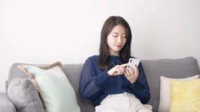 Young asian woman using a smart phone in the room.