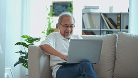 Asian elderly man sit alone on sofa. The retiring life of old people  seem to be lonely but technology makes it possible to communicate to Internet Wi-Fi, video call or social media very quickly.