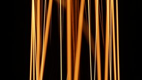 Extremely close view. Macro. Tungsten filaments glow with a warm orange light.