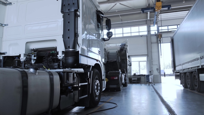 The lorry is standing on the inspection pit at the truck service station. Cinematic side view of the truck cab Royalty-Free Stock Footage #1070573704