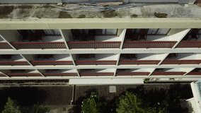 4K Video from drone flying down and removing white wall building with balconies and railings