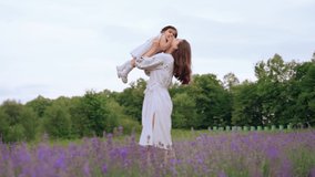Motion of young loving caucasian mother enjoying time with little baby daughter, playing, kissing and laughing. Stunning lady wearing dress throwing kid up, blooming lavender field on background. - Powered by Shutterstock - Get 15% off with code: PIKWIZARD15