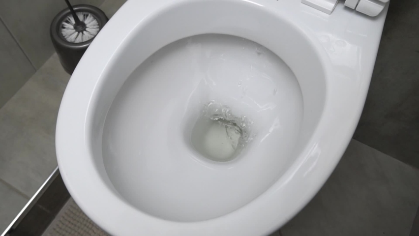 Flush toilet. Water flushes the toilet. The flow of water is clearly visible. Flashing water in a ceramic toilet. slow motion Royalty-Free Stock Footage #1070597899