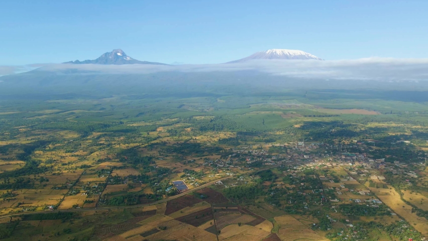 Kenya landscape with a village, Kilimanjaro and Amboseli national park - tracking, drone aerial view