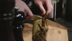 Chef cuts venison meat spiced ribs on wooden cut board, after baking in oven. Close up, slow motion shot. - Powered by Shutterstock - Get 15% off with code: PIKWIZARD15