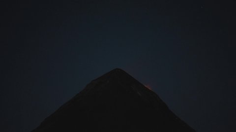 Fuego volcano erupting in Guatemala during the night, black background