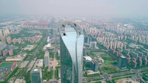 Suzhou, China - September 04, 2020: Aerial orbital view of a skyscaper under construction with reflections on the glass windows in a business district of Suzhou, China. IFS building.