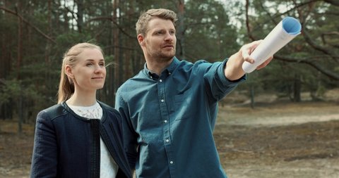 young couple looking and choosing a plot of land for house construction