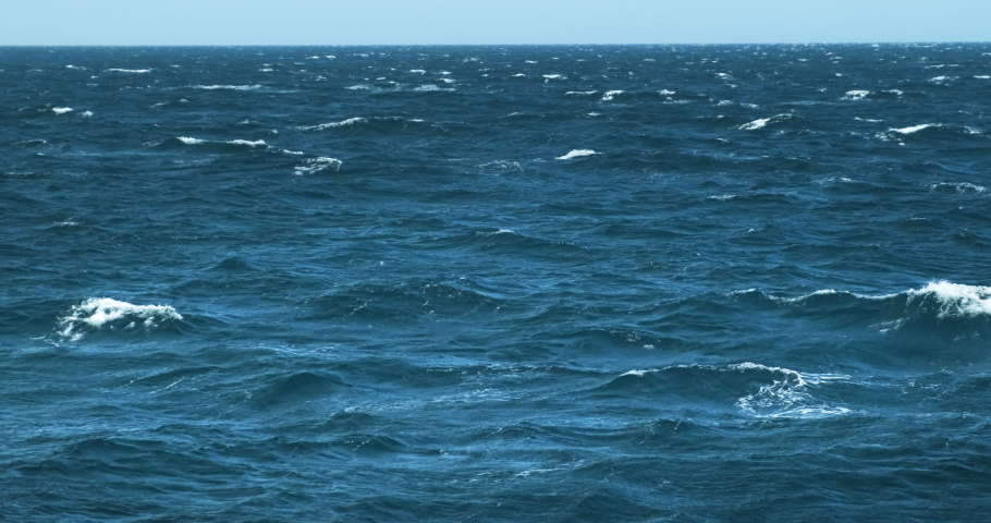 Blue sea with white waves scallops on clear day. Marine background. Bad stormy weather in open azure sea. View from ship on waving restless surface of ripples nautical texture. Dark ocean water. 4k | Shutterstock HD Video #1070617603