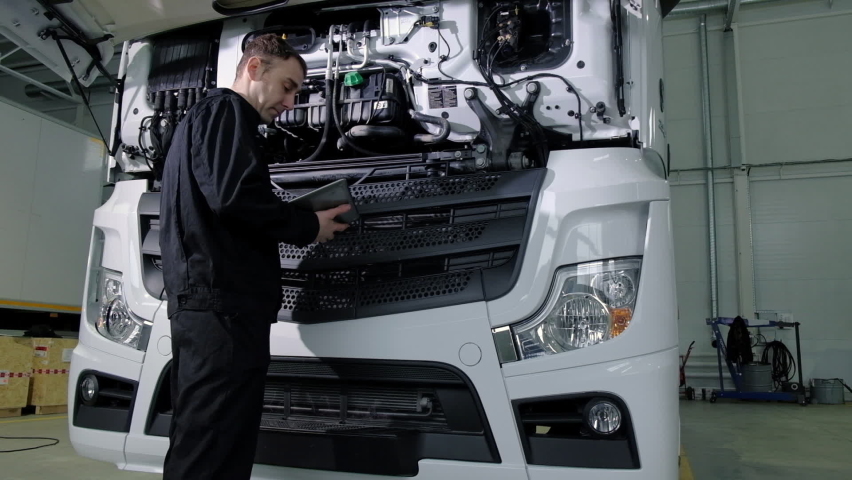 Repair diagnostics and maintenance of cars in service center. mechanic engineer of car service inspects transport cargo uses tablet to search for errors and breakdowns and writes data to the computer Royalty-Free Stock Footage #1070618905