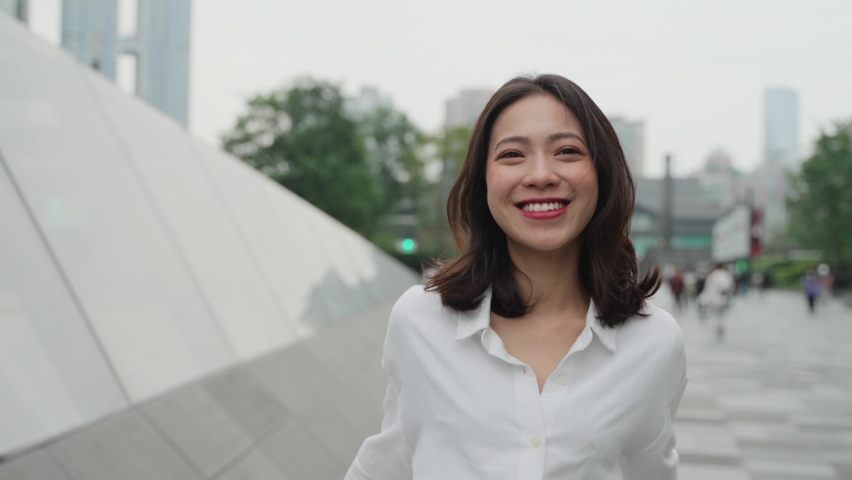 4k slow motion front view of pretty young asian lady walking in the urban street smile at camera real people in the city 4k footage Royalty-Free Stock Footage #1070621692