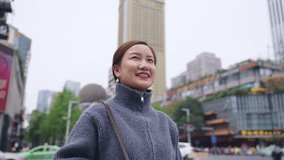 slow motion 4k clip of happy asian woman looking around in the urban city street with Moving Around 360 Camera