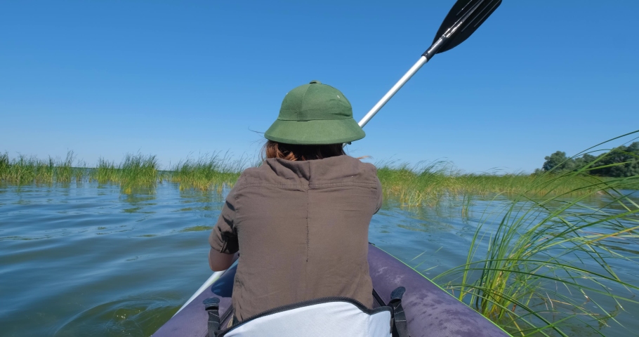 Young woman traveler with hat swim in the kayak.