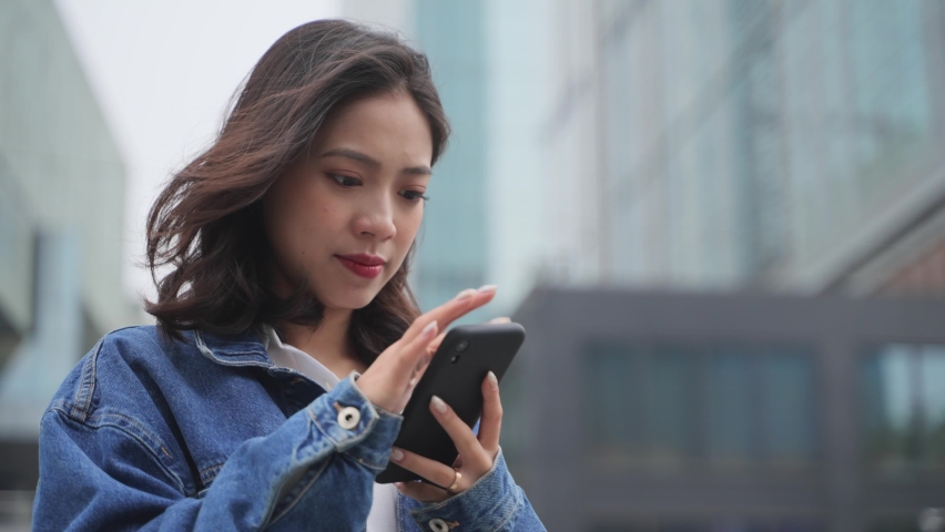 4k slow motion close up of one young asian woman holding mobile phone typing reading news online in the urban city place at Chengdu China | Shutterstock HD Video #1070626462