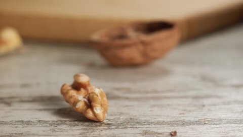 Walnut falling and cracking on close-up on a wooden table