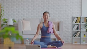 Asian Athlete woman take a break in yoga class video conference online dancing and happiness with her friends in class isolation at home due virus pandemic.Happiness workout exercise concept