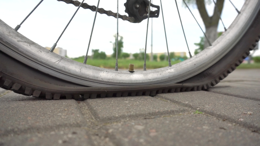A man inflates a wheel in a bicycle with a pump, close-up, transport