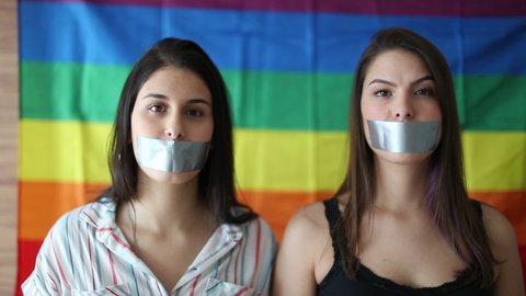 Two women censored with mouth tape. LGBT rights, censorship concept