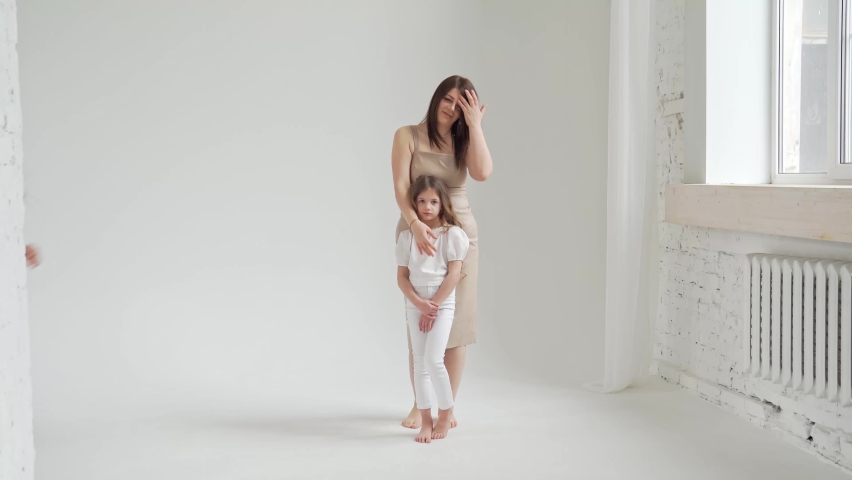 Mom and daughter pose in a white photo studio for a photo shoot. backstage. Happy family. single mother with children.