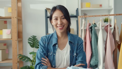 Portrait of young Asia lady fashion designer feeling happy smile, arms crossed and looking to camera while working clothing store in home office. Small business owner, online market delivery concept.