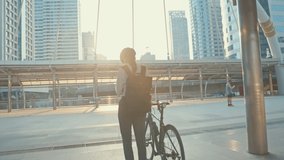 Asian businesswoman carry backpack wear anti virus protection mask take bicycle walk and check phone in city street go to work at office. commute to work, Business commuter for covid-19 concept. - Powered by Shutterstock - Get 15% off with code: PIKWIZARD15